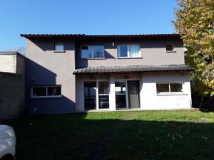 a house with a lawn in front of it at Departamento Meliades in El Bolsón