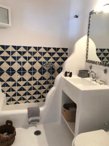 La salle de bains est pourvue d'un lavabo, de toilettes et d'une baignoire. dans l'établissement Beachfront Mykonos Guest House, à Ornos