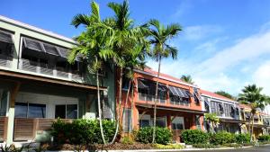 a building with palm trees in front of it at Le Panoramic in Les Trois-Îlets