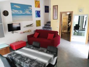 un soggiorno con divano rosso e TV di La casa di Gio a Varazze