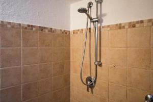e bagno con doccia e piastrelle marroni. di Dimora Zafferano - Guest House Ostuni a Ostuni