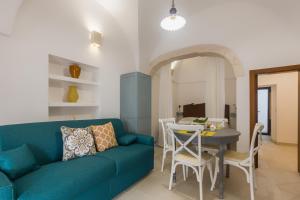 un soggiorno con divano blu e tavolo di Dimora Zafferano - Guest House Ostuni a Ostuni