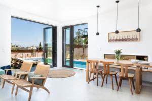 een keuken en eetkamer met een tafel en stoelen bij Fos Villa, a Luxe House with Private Heated Pool in Galatás