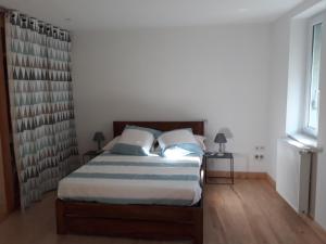 una camera da letto con un letto con due cuscini di Gite d'Emilie - Cahors Centre Ville avec Garage - 3 étoiles a Cahors