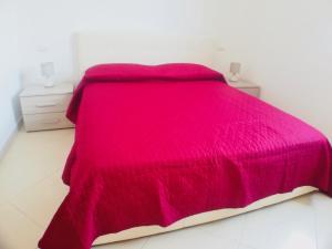 una camera con letto rosa e 2 comodini di La Casa di Daisy a Santa Maria al Bagno