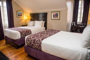 ein Hotelzimmer mit 2 Betten und einem Tisch in der Unterkunft Inn on Ursulines, a French Quarter Guest Houses Property in New Orleans