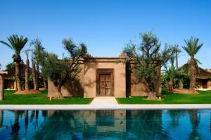 a villa with a swimming pool and trees at Hotel Les Cinq Djellabas in Douar Caïd Layadi