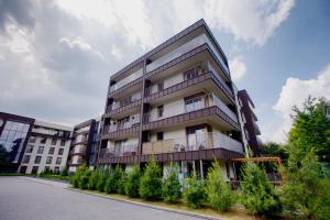 un edificio de apartamentos alto con árboles delante de él en Apartament "Park Lotników", en Cracovia