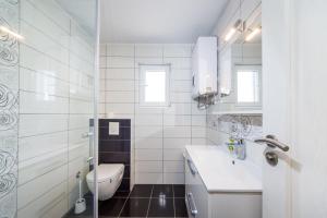a white bathroom with a toilet and a sink at Apartmani Paradise in Petrcane +67 photos