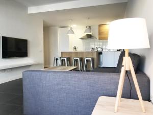 Una sala de estar con un sofá y una mesa con una lámpara. en Apartamento alto stading en urbanización de lujo, en Villaverde