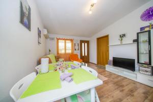 a living room with a table and a tv at Holiday Home Jere in Postira