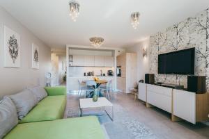 sala de estar con sofá verde y TV de pantalla plana en Eight - Luxury Apartment with Beautiful View, en Cracovia