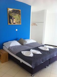 una camera blu con un letto e due asciugamani bianchi di Questel BronQ a Chã da Igreja
