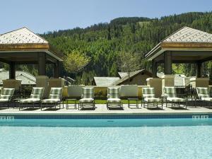 a group of chairs sitting next to a swimming pool at The Vail Collection at the Ritz Carlton Residences Vail in Vail