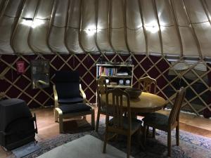 a room with a table and chairs in a yurt at Yurt luxury + Bathhouse in Callington