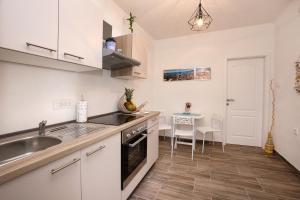 - une cuisine avec des placards blancs, un évier et une table dans l'établissement Apartment Barka, à Split