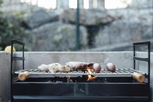 una parrilla con carne y verduras cocinando en ella en The Cantabrian Apartamentos, en Serdió