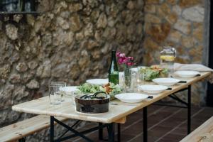 una mesa de madera con tazones y botellas de vino. en The Cantabrian Apartamentos, en Serdió