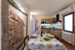 uma cozinha com uma mesa e uma parede de tijolos em Il Limone em Florença
