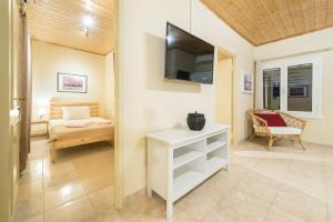 a room with a bed and a television on a wall at Amygdalia Villa with Private Pool, by ZanteWize in Pandokrátor