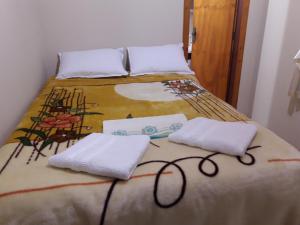 a bed with two white towels on top of it at Pousada Viva Serra in Urubici