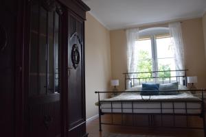 a bedroom with a bed and a window at Kamienica in Duszniki Zdrój