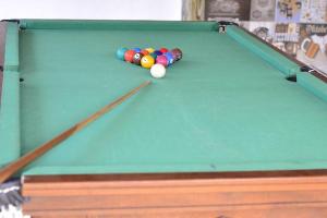 a pool table with balls on top of it at Hostel Quintal do Rosa in Praia do Rosa