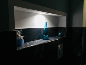 パレルモにあるGò Gò Houseのバスルーム(鏡、棚に青いボトル付)