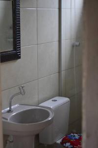Hostel Quintal do Rosa في برايا دو روزا: حمام مع مرحاض ومغسلة