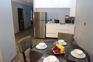 
a kitchen with a table and chairs and a refrigerator at BLVD Hotel & Suites - Walking Distance to Hollywood Walk of Fame in Los Angeles
