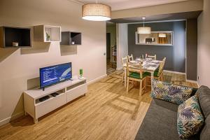 uma sala de estar com um sofá e uma sala de jantar em Aromas Flavors Tours - Apartment Velasquez no Porto