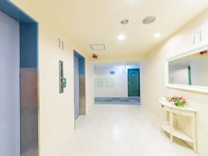 a hallway of a hospital with a door and a table at Hotel Abest Naha Kokusai Street in Naha