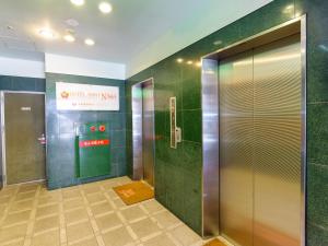 a bathroom with an elevator and a sign on the wall at Hotel Abest Naha Kokusai Street in Naha