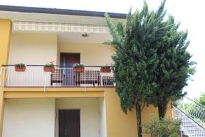 ein gelbes Haus mit Topfpflanzen auf einem Balkon in der Unterkunft Casamia B&B in Castelletto sopra Ticino
