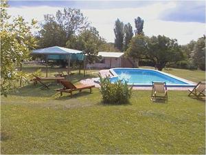 un patio con una piscina con sillas y una mesa en Cabanas Las Achiras en San Javier