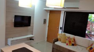 ein Wohnzimmer mit einem Sofa und einem Flachbild-TV in der Unterkunft Ap Studio 230 Eco Paradise in Cumbuco
