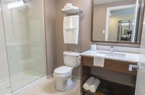 a bathroom with a toilet a sink and a mirror at MStar Hotel in Kitimat