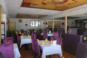 un restaurante con mesas blancas y sillas moradas en Macintyre Motor Inn, en Goondiwindi