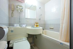 a bathroom with a sink and a toilet and a tub at Hotel Ascent Hamamatsu in Hamamatsu