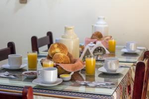 a table with a breakfast of bread and orange juice at Totorani Inn in Puno