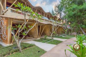 an exterior view of a building with trees and plants at Pearl of Trawangan in Gili Trawangan