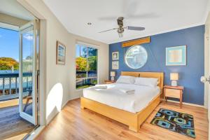 ein Schlafzimmer mit einem Bett und einer blauen Wand in der Unterkunft All Decked Out - Port Willunga - C21 SouthCoast Holidays in Port Willunga + 7 Fotos