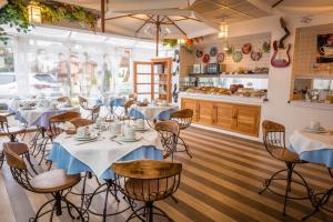 a restaurant with white tables and chairs and a counter at Pousada Piano Piano in Campos do Jordão