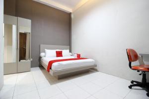 a bedroom with a bed and a desk and a chair at RedDoorz Plus near UPN Jogjakarta 2 in Yogyakarta