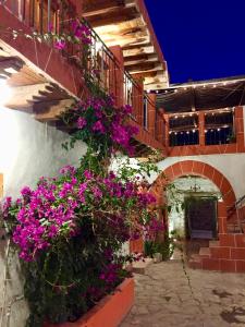 a building with purple flowers on the side of it at Hotel Hacienda Encantada in Real de Catorce
