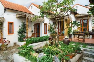 a house with a garden in front of it at Hue River Side Villa in Hue