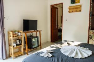 a bedroom with a bed with a tv and a televisionictericter at Hue River Side Villa in Hue