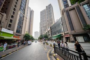 a street in a city with people walking on the sidewalk at Xing Yu Legend Service Apartment Canton Fair Branch in Guangzhou