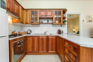 a kitchen with wooden cabinets and granite counter tops at Barossa Vineyard Cottages in Bethany