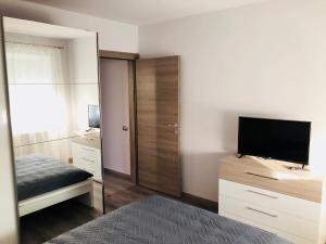 uma sala com um quarto com uma cama e uma televisão em Apartament Diego em Constança